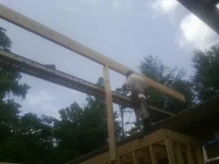 Carpenter setting a ridge beam over a new addition frame — Ice Dam Removal by Roofing Brothers in Oakwood